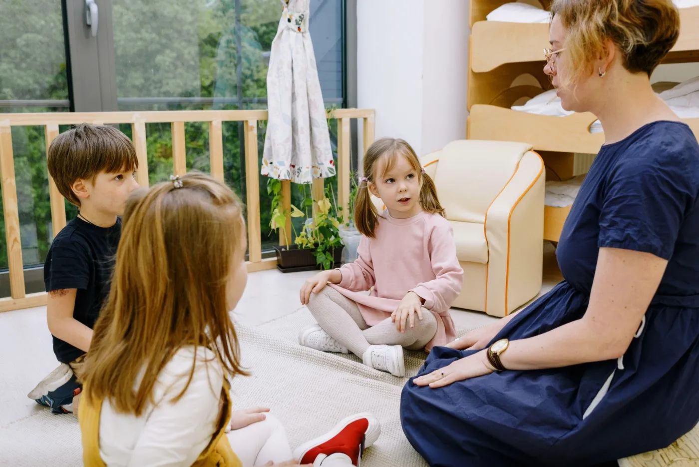 A ministry leader sitting and talking with three children