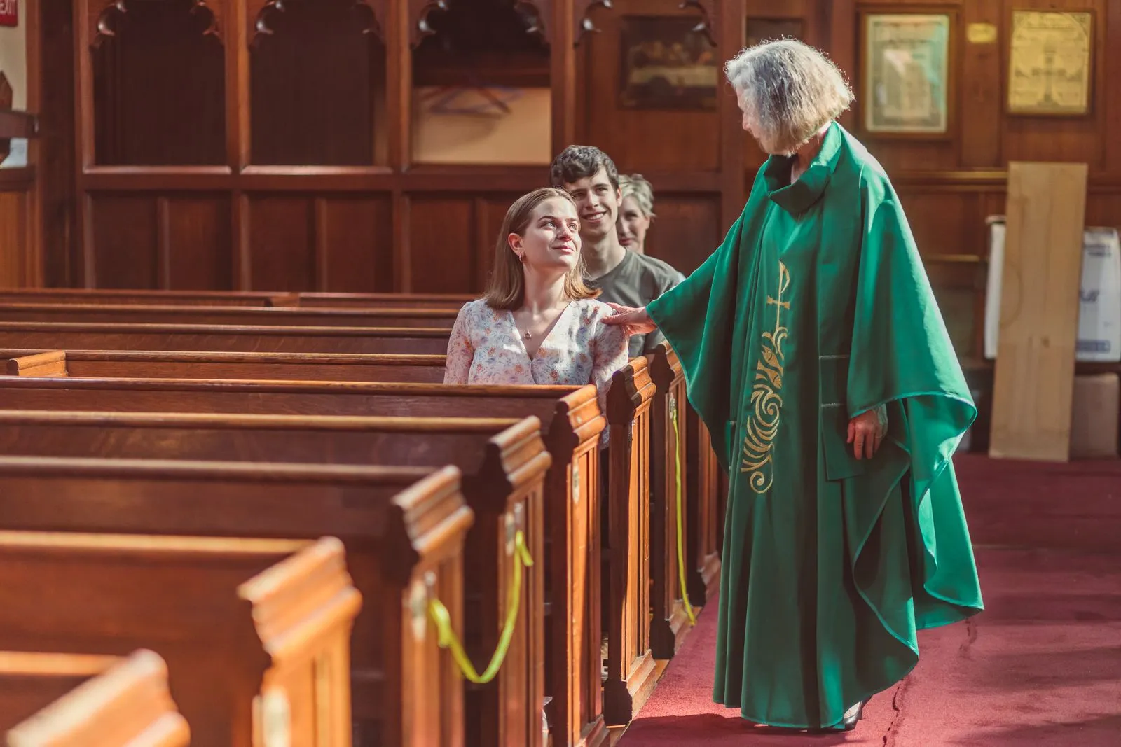 Minister greeting visitors aisle after service